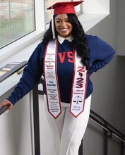 Load image into Gallery viewer, Teekajame Creations custom white satin graduation stole with red text worn by a graduate in a navy sweatshirt.