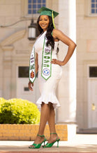 Load image into Gallery viewer, Teekajame Creations custom white satin graduation stole with green lettering worn by a graduate in a white dress
